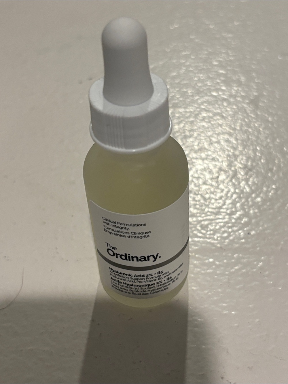 The Ordinary Serum Bottle — White Cap with Pale Yellow Liquid
